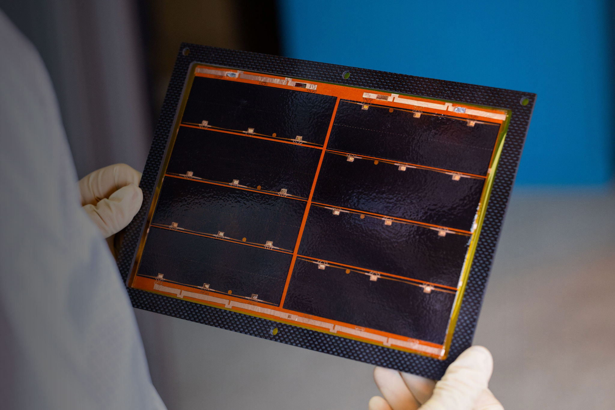 Lab technician holding an Integrated Solar Panel Module