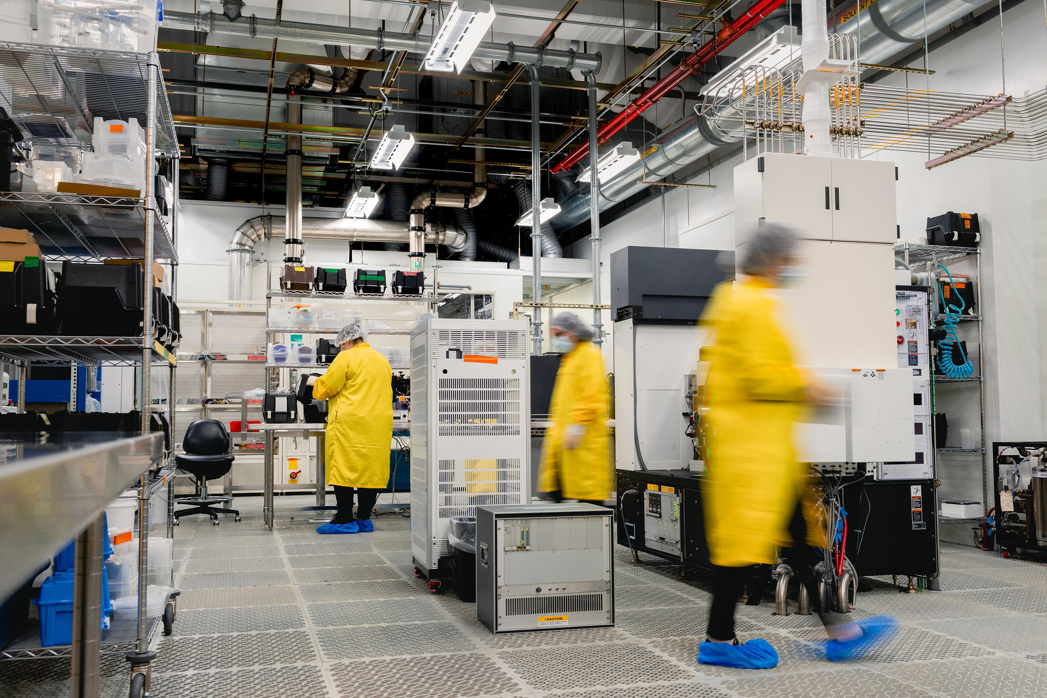 wide angle shot of workers in yellow lab coats